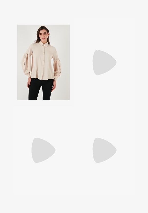 Beige skjorte med knapper, krave og puffede lange ærmer. Glat stof med en afslappet pasform, der har en lige kant.; En knælang nederdel i et let stof med et abstrakt mønster i beige, brun og grøn. Har en tætsiddende talje og en bølgende design.; Rosa ruskinds højhælede sandal med blokhæl, åbent tåparti og ankelrem med en detalje af guldspænde. Flad frontrem.; Brun faux læder skuldertaske med buet form, minimal syning og en guldtonet hardwaredetalje. Har en top lynlåslukning og justerbar rem.