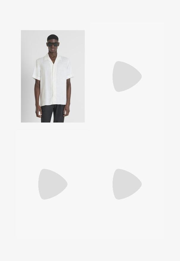 Camisa blanca de manga corta con botones y tejido texturizado, que presenta un cuello con muesca y un sutil detalle de paneles. Lleva puestas gafas de sol negras.; Pantalones de mezclilla negra con corte recto, diseño de cinco bolsillos y cierre frontal con botón. Textura suave con detalles de costura mínimos.; Mocasín de cuero negro con un acabado suave, que cuenta con un diseño de costura y un acento decorativo de cadena de metal en el empeine. Tacón plano.; Juego de cinco anillos de plata con varios diseños: una banda lisa, un patrón retorcido, una textura trenzada y dos con acentos con corte.