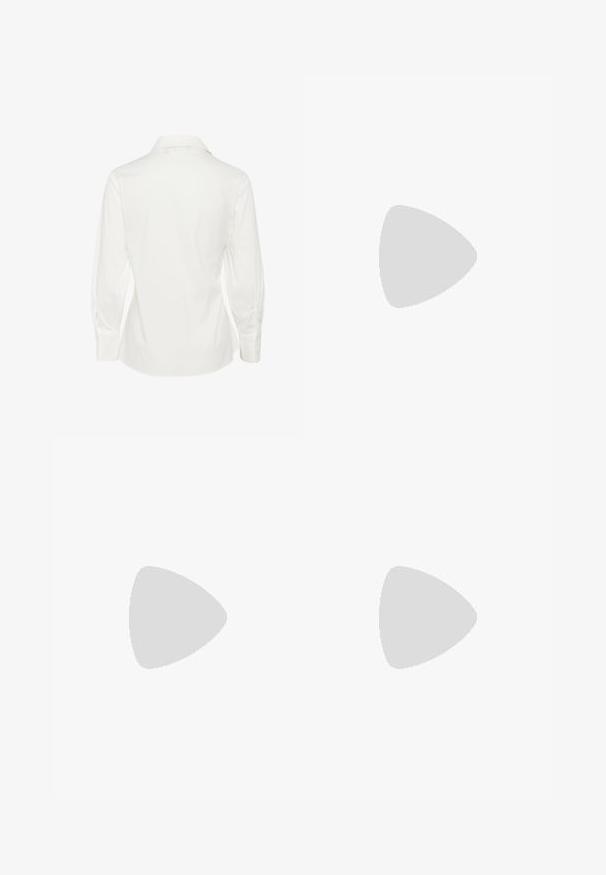 White long-sleeve shirt with a pointed collar, featuring a smooth texture and fitted shape, detailed with buttoned cuffs and a curved hem.; Beige wide-leg trousers made of soft cotton, featuring a belt and side pockets. The fabric has a smooth texture with folded cuffs.; Brown suede athletic shoes with mesh panels and white stripes. Paired with loose blue denim jeans. Green textured surface beneath.; Brown leather tote bag with a smooth texture, open top design, and two shoulder straps. Features minimal stitching and no visible hardware.