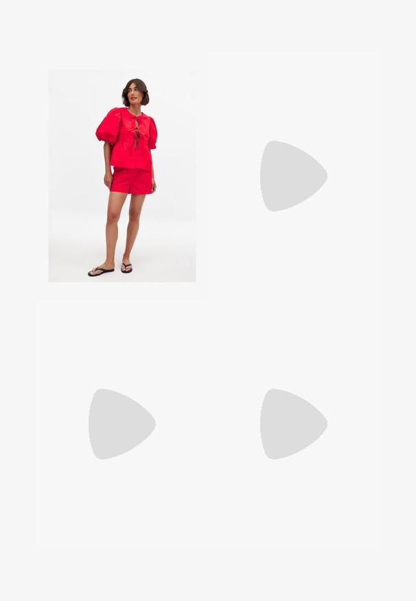 Rode top met pofmouwen en een strikdetail aan de voorkant, gecombineerd met bijpassende rode shorts. Het model draagt zwarte slippers op een effen achtergrond.; Mid blauwe denim shorts met een losse pasvorm. Heeft twee achterzakken en een schone zoomlijn. Gemaakt van stevig denim stof.; Rode leren kitten-heel mules met een afgeronde open teen en een decoratieve strikdetail op de wreef. Slanke hak en een gladde textuur.; Gouden metalen zonnebril met grijze lenzen, een octagonale vorm, dunne pootjes en een multicolor gestreept detail aan de binnenkant van de arm.; Strohandtas met een brede, waaiervormige ontwerp, zwarte leren handvatten en zwarte bloemaccenten aan één kant.