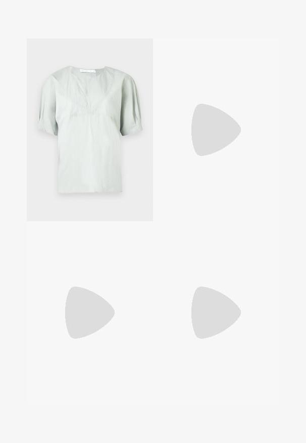 Jasnoszara bluzka z krótkim rękawem i okrągłym dekoltem o subtelnej fakturze. Charakteryzuje się luźnym krojem i lekko bufkami na rękawach dla swobody ruchów.; Czarne spodnie szerokie w nogawkach z fasonem w stylu owijanym, charakteryzujące się gładką teksturą, wysokim stanem oraz detalem w postaci wiązania z boku. Wykonane z lekkiego materiału.; Czarne skórzane mule z odkrytymi palcami o smukłym, zakrzywionym kształcie, wysokim obcasie typu stiletto i gładkiej fakturze. Wnętrze ma kontrastujący jasny kolor.; Czarna, miękka skórzana torba o unikalnym skręconym wzorze. Posiada krótki uchwyt oraz odpinany pasek na ramię. Styl minimalistyczny.