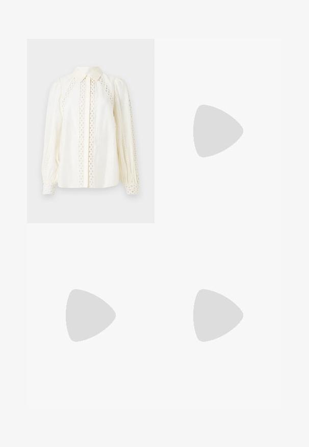 Weiße Bluse mit einem Knopfkragen, strukturiertem Stoff und filigranen Spitzenausschnitten an den Seiten und Ärmeln.; Schwarze weite Hosen mit glatter Textur, mit flacher Vorderseite, Falten und maßgeschneidertem Bund. Keine sichtbaren Beschläge oder Muster.; Schwarzer Lackleder-Stiefelette mit spitzer Zehe und einem mittelhohen Blockabsatz. Glatte Textur und minimalistisches Design.; Schwarze Handtasche mit strukturierter Form, glatter Textur und einem metallischen Verschluss. Kombiniert mit weiten schwarzen Hosen und offenen Sandalen auf einem Holzboden.