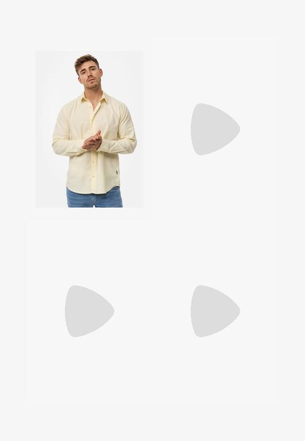 Camicia a maniche lunghe di color giallo chiaro, realizzata in un tessuto testurizzato, con chiusura a bottoni sul davanti e polsini, abbinata a jeans azzurri chiari.; Jeans skinny in denim grigio sbiadito, con dettagli strappati sulle ginocchia, abbinati a sneakers bianche. Texture liscia, design slim fit.; Sneakers in pelle bianca con perforazioni, punta rotonda, suola piatta e lacci spessi, con logo swoosh visibile e "AIR" sul tallone.; Orologio da polso in acciaio inossidabile argento con quadrante blu navy, indici metallici e finestra della data alle 3. Resistente all'acqua fino a 50 metri.