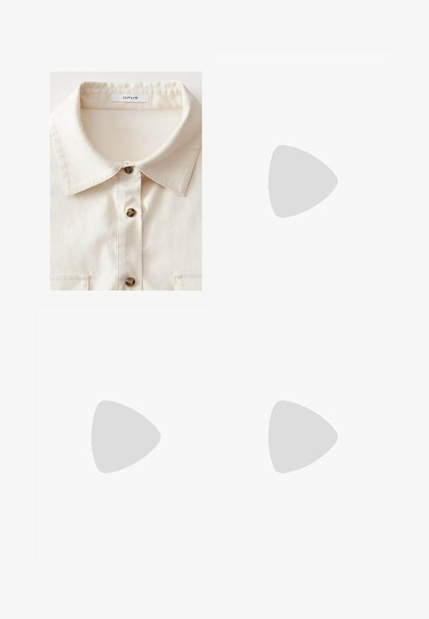 Camicia crema con colletto strutturato, dotata di cinque bottoni marroni scuri e una tasca sul petto, realizzata in un tessuto liscio.; T-shirt bianco a maniche corte con una vestibilità rilassata e una texture smock in vita. Realizzato in tessuto morbido e leggero.; Pantaloni bianchi a gamba larga realizzati in tessuto leggero, dotati di una vita elastica e di un cordino per una vestibilità regolabile. Texture liscia.; Sneakers di pelle bianca con strisce nere, suola crema e lacci chiari. Indossati con calze bianche a coste, posizionati su uno sfondo blu.