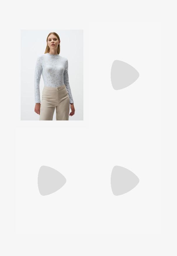 Helles blauen Spitzenoberteil mit langen Ärmeln, das mit floralen Mustern, einem hohen Kragen und einer figurbetonenden Silhouette versehen ist, kombiniert mit beigen, hochtaillierten Hosen.; Weiße weit geschnittene Hose aus leichtem Stoff. Mit einem elastischen Bund und Kordelzug sowie Seitentaschen. Glatte Textur.; Helle rosa Sportschuhe mit schrägen Nähten, weißen Sohlen und drei seitlichen Streifen. Getragen mit gestreiften weißen Socken auf grünem Untergrund.; Weiße synthetische Handtasche in dreieckiger Form, flache Vorderklappe und Schleifendetail, verstellbarer Trageriemen, glatte Textur und minimalistisches Design.