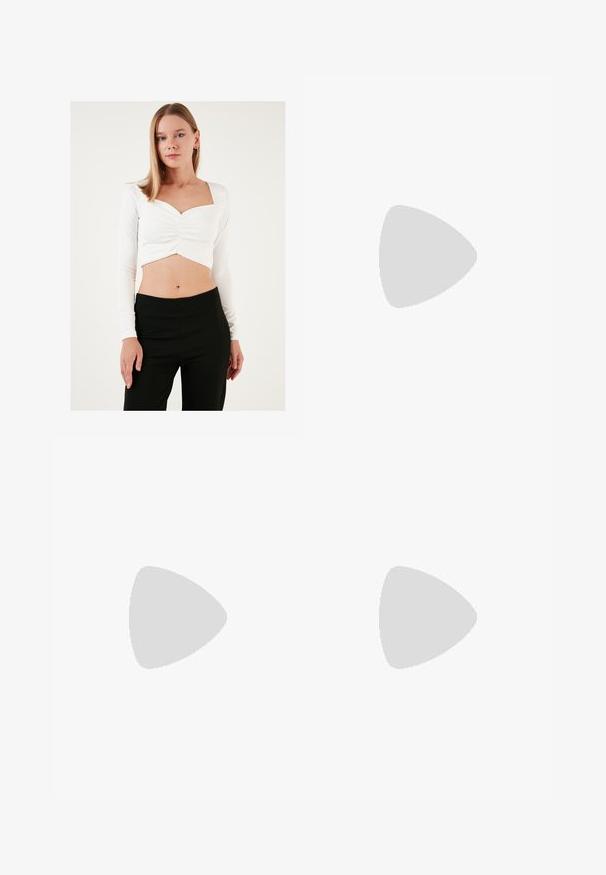 Hvid langærmet cropped top med firkantet halsudskæring og rynket centerdetalje, sat sammen med sorte høj taljede bukser. Glat tekstur.; Lyserøde brede bukser lavet af glat stof. Har en struktureret talje og lige, flydende ben, uden synlige mønstre eller metaldele.; Hvide højhælede sandaler med en glat satin-overdel, bred blokhæl og ankelrem med en lille spænde. Glat i tekstur, minimalistisk design.; Lyserød læderhandtaske med en buet klap, enkel skulderrem og rene linjer. Tasken har en glat overflade og et minimalistisk design.