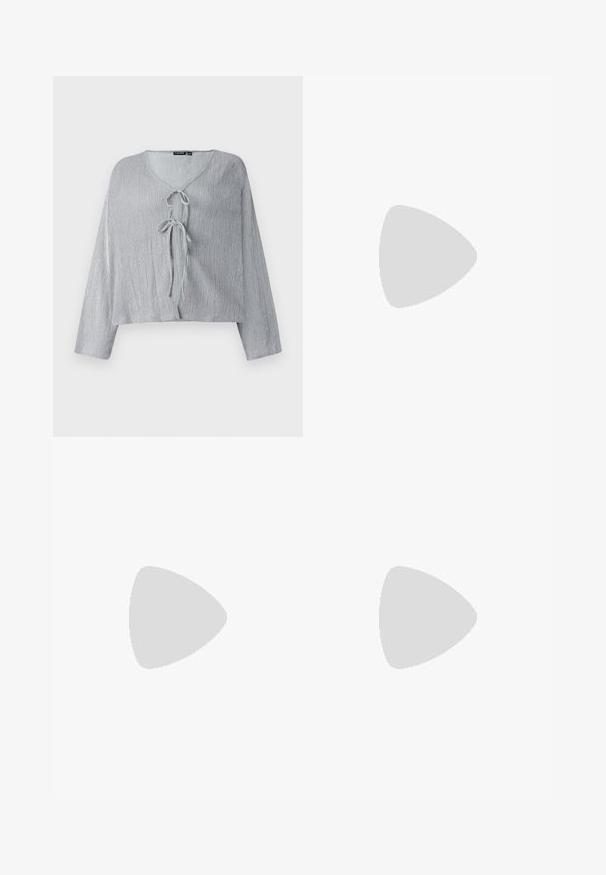 Light grey cropped blouse with long sleeves, V-neck, and front tie closure. Textured fabric displays subtle vertical lines.; Beige corduroy trousers with a loose fit, featuring a drawstring waist, two front pockets, and vertical ribbed texture.; Light grey sneaker made of suede and mesh, featuring three white stripes, round toe, and a gum rubber sole. Gold logo accent near laces.; Green tank top with lace detail at the shoulder and neckline, featuring a fitted design and soft fabric. Paired with light-colored trousers.