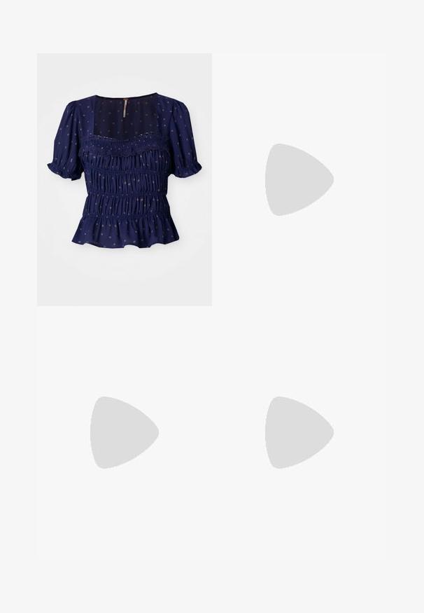 Blouse bleu marine avec des manches courtes à volants, design smocké et motifs floraux. Elle présente un col carré et un ourlet à volants.; Jeans blancs taille haute avec une coupe large, en denim ; comportent cinq poches, des rivets en cuivre et une fermeture éclair.; Des chaussures en daim bleu avec des rayures roses et des lacets blancs, dotées d'une semelle en caoutchouc gomme, assorties à un pantalon en denim ample sur une surface verte.; Une paire de lunettes de soleil rectangulaires avec des montures translucides bleu clair et des verres gris foncé, présentant des branches droites et des détails matériels minimaux.