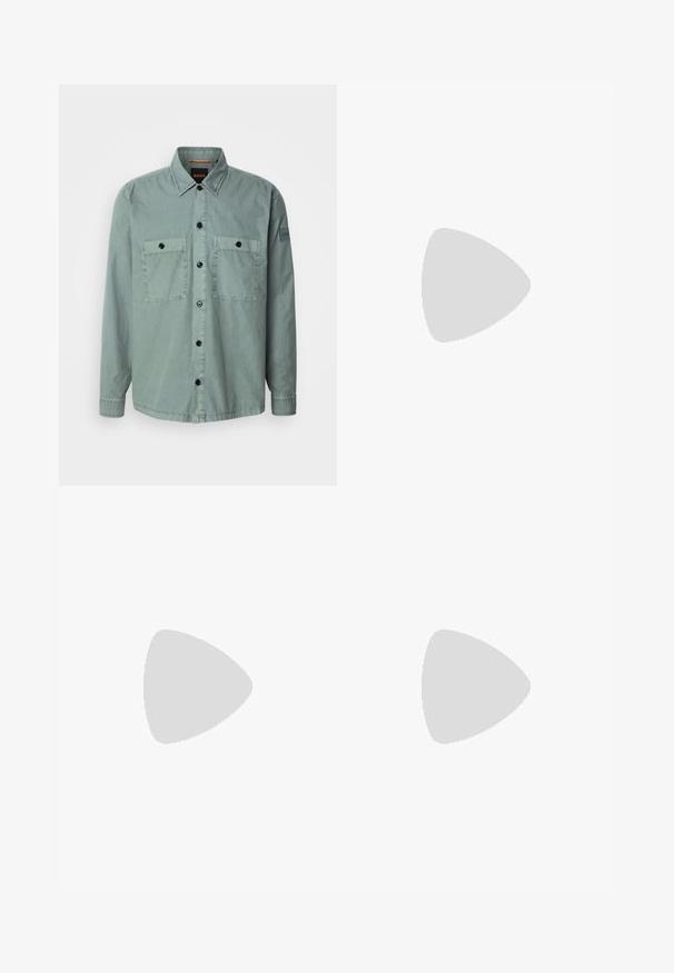 Camisa de botones verde claro, hecha de una tela suave, con dos bolsillos en el pecho y botones negros. Cuello clásico y mangas largas con puños abotonados.; Camiseta blanca de algodón con mangas cortas, cuello redondo y una pequeña etiqueta azul "HUGO" en la parte superior del pecho. Textura suave, ajuste clásico.; Pantalones negros hechos de una tela suave con una textura lisa, que cuentan con una cintura elástica y cordón, piernas anchas y costuras laterales.; Zapatillas blancas hechas de materiales texturizados con acentos de costura, que presentan un diseño de cordones y un logo en la lengüeta, llevadas con jeans de mezclilla.