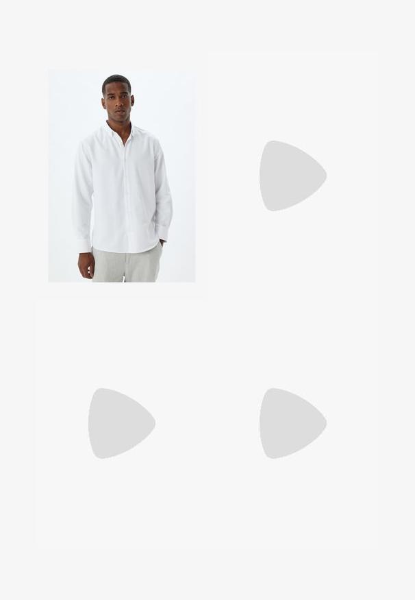 Camisa blanca de manga larga con botones y cuello, con una textura de tela suave y placket de botones tradicional. Lleva puestos unos pantalones gris claro.; Pantalones gris ajustados hechos de tela texturizada, con un diseño de pierna recta, pliegues frontales y una cinturilla estándar con lazos para cinturón.; Zapatos de cuero negro con punta redondeada, diseño de cordones y suela gruesa y texturizada. Combinados con pantalones negros a medida y un suéter acanalado.; Corbata negra estrecha con un patrón texturizado de estrías diagonales. Presenta una punta puntiaguda y un acabado suave. Adecuada para vestimenta formal.