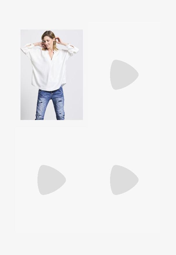 Weißes Langarmbluse mit V-Ausschnitt und geknöpften Manschetten. Verfügt über eine lockere Passform und eine glatte Textur. Kombiniert mit ausgebleichten blauen Jeans.; Weite Denim-Jeans in Mittelblau mit zwei Gesäßtaschen, Metallknopfverschluss und kontrastierenden Nähten.; Weiße Sneakers aus glattem Synthetikmaterial mit Wildlederakzenten. Mit einer strukturierten Sohle, Schnürdesign und dezenten seitlichen Details.; Weiße Lederhandtasche mit strukturiertem Design, ausgestattet mit einem oberen Griff und einem goldfarbenen Verschluss. Glatte Textur und minimalistische Akzente.