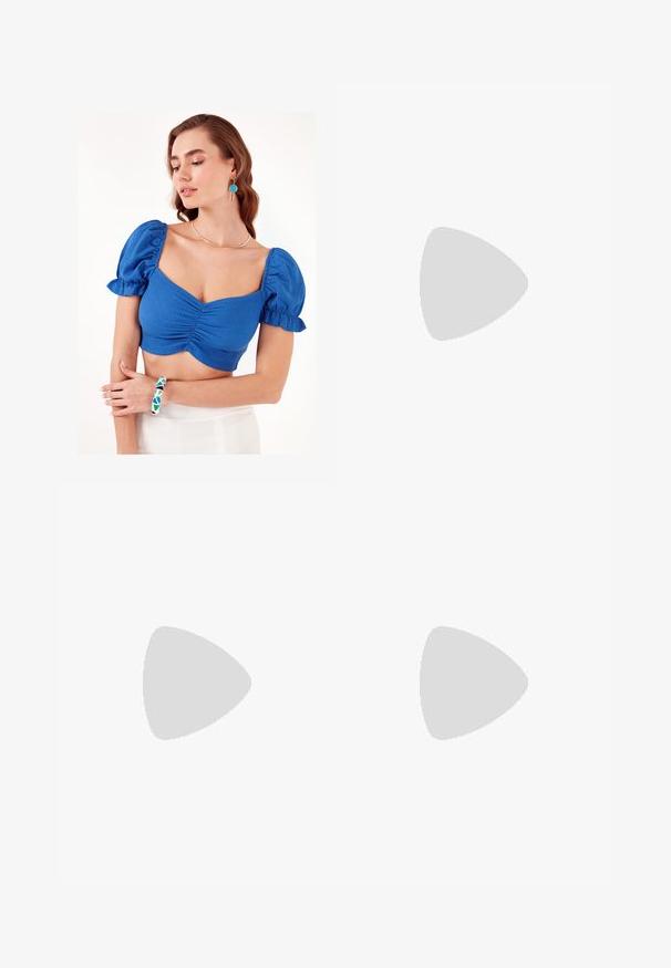 Blå cropped top med puffede ærmer og rynket frontdetalje. Modellen bærer et geometrisk mønstrede armbånd og en simpel halskæde. Baggrunden er ensfarvet hvid.; Sorte polyester culotte bukser med elastisk talje, to forpiber og en løs silhuet. Ingen synlige mønstre eller hardware detaljer.; Blå ruskindsko med pink striber og hvide snørebånd, med en sål af gummi, parret med løse denimbukser på en grøn overflade.; Sort læder tote taske med glat tekstur, rektangulær form og to lange hanke. Ingen synlig hardware eller udsmykninger.