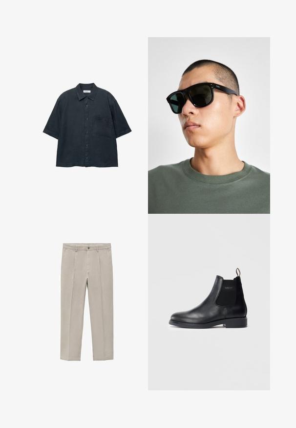 Cămășuță scurtă cu mânecă închisă la culoare, fabricată dintr-un material ușor, având un buzunar pe piept și un guler clasic.; Pantaloni bej deschis dintr-un amestec de bumbac, cu un design dreapt, pliuri frontale, închidere cu nasture și buzunare laterale.; Botă Chelsea din piele neagră, cu panouri laterale elastice, toc jos, cu etichetă de prindere la călcâi și logo-ul GANT pe panoul lateral exterior.; Ochelari de soare rectangulari negri cu lentile închise, având o formă distinctivă și branding pe templu. Purtați de o persoană într-o cămașă verde.