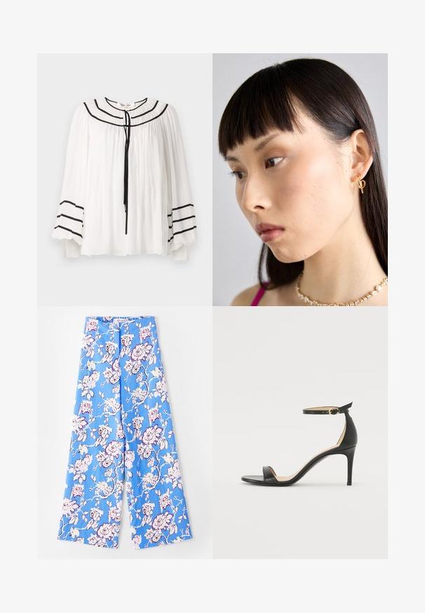 Biała bluzka z długimi rękawami, z czarnymi paskami i plisowanym wykończeniem. Okrągły dekolt z wiązaniem z przodu.; Niebieskie spodnie w kwiaty z pastelowym wzorem róż. Materiał jest gładki, z luźnym krojem, szerokimi nogawkami i elastycznym pasem.; Czarne skórzane sandały na wysokim obcasie z paskiem na kostce. Charakteryzują się gładką fakturą, otwartym noskiem i cienkim obcasem. Złoty detal z klamrą.; Złoty kolczyk w kształcie obrączki noszony w prawym uchu, z otwartym wzornictwem. Modelka ma proste, ciemne włosy i minimalny makijaż.