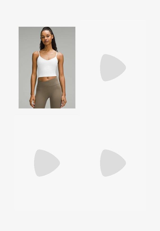 Valkoinen lyhyt toppi ohuilla olkaimilla, jossa on V-päinen kaula-aukko. Yhdistetty korkeavyötäröisiin, vaaleanruskeisiin legginsseihin. Sileä kangas.; Ruskeat tekonahka-housut, joissa on teksturoitu pinta, jossa on kuun muotoinen kuvio, korkeavyötäröinen malli ja suora lahje.; Valkoiset paksut lenkkarit, joissa on teksturoitu päällinen, verkkomaiset paneelit ja paksut kumipohjat, joissa on merkittävä kuviointi. Nauhat ja vetotappi mukana.; Ruskea nahkalaukku, jossa on kaksi tukevasti kantavaa kahvaa, suorakaiteen muotoinen, sileä pinta ja vetoketjukiinnitys. Minimalistinen muotoilu ilman näkyviä kuvioita.