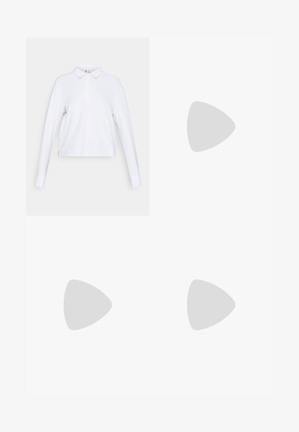 Polo a maniche lunghe bianco con colletto a bottoni e vestibilità leggermente ampia, esposto su uno sfondo bianco semplice.; Bermuda rosa realizzati in un tessuto morbido e leggero. Presentano una chiusura con bottone, tasche frontali e un charm metallico decorativo sulla cerniera.; Scarpe da ginnastica rosa chiaro con parte superiore in rete beige, dettagli in pelle marrone, suola nera e logo con tre strisce. Punta arrotondata e design con lacci.; Borsa a spalla in pelle marrone chiaro con forma curva, hardware dorato e manico superiore. Indossata con un maglione lavorato a maglia crema e jeans di denim.