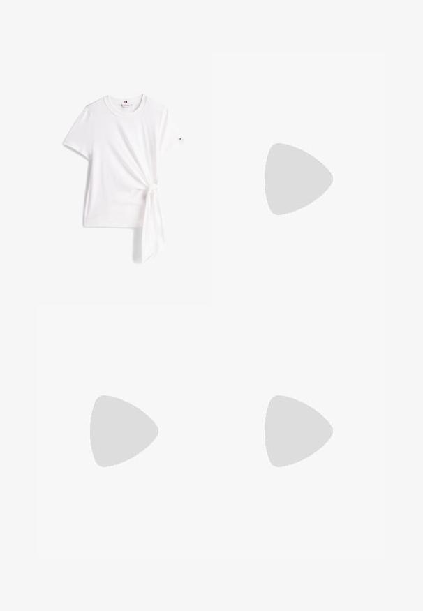 Bela bombažna majica s kratkimi rokavi, ki ima detajl z vezanjem na strani in okroglo ovratnico. Logotip blagovne znamke je vidno na rokavu.; Črne atletske hlače ohlapnega kroja, z elastičnim pasom in vrvico. Imajo stranske žepe in gladko, teksturirano tkanino.; Bele usnjene superge z gladko teksturo, svetlo modrim detaljem na peti, zlatimi kovinskimi elementi in dvignjenim logotipom blagovne znamke na strani.; Bela sintetična usnjena torbica z kratkimi ročaji, nastavljivim ramenskim trakom in zlatim kovinskim okovjem; na sprednji strani je subtilen logotip.