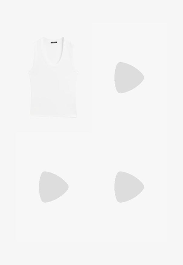Witte mouwloze tanktop met een ronde hals, gemaakt van ribbelstof; eenvoudig ontwerp zonder patronen of versieringen.; Zwarte wijde broek met hoge taille, met een soepele textuur en twee plooien aan de voorkant. Ontworpen met een strakke, op maat gemaakte uitstraling.; Bruine suède sneakers met witte accenten en veters. Rubberen gumzool. Draag met witte sokken met zwarte strepen. Groene gestructureerde vloer.; Zwarte oversized zonnebril met ovale lenzen, een glad plastic montuur en gouden accenten op de pootjes. Donkere lenzen bieden bescherming tegen de zon.