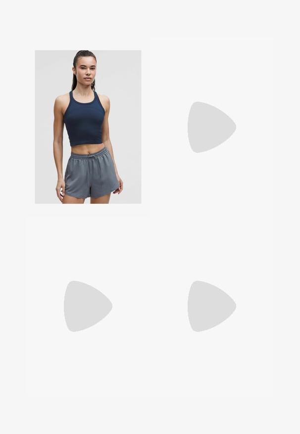 Námořnická modrá hřejivá sportovní crop top s tenkými ramínky, spárovaný se světle šedými šortkami se elastickým pasem, které mají uvolněný střih a šňůrku.; Černé sportovní šortky s elastickým pasem, vnitřním podšívkou a bočními rozparky. Na levé přední straně je bílý logo Nike.; Hnědé semišové kotníkové boty s jemnou vnitřní podšívkou, kulatou špičkou a plochou gumovou podrážkou. Mají šitý šev a zadní poutko.; Sluneční brýle s želvovinovým vzorem, geometrickým designem, žlutými skly a kovovými akcenty na stranách. Široký rám a matný povrch.