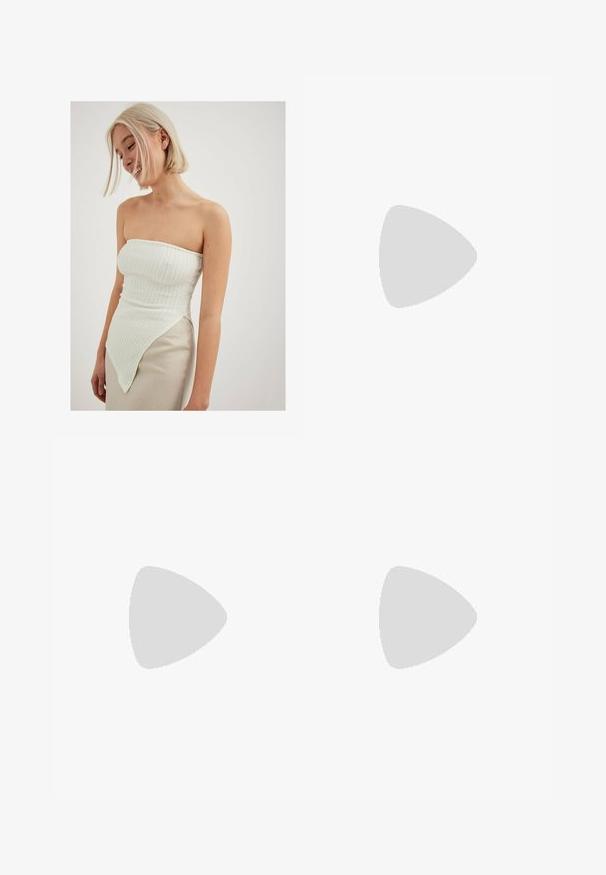 Top blanco sin tirantes con canalé texturizado, que presenta un dobladillo asimétrico que se extiende hacia un lado, combinado con una falda de un beige claro.; NA-KD FULL LENGTH  - Vaqueros boyfriend - light blue; Zapatillas blancas de cuero con acentos grises, puntera perforada, cordones planos, cuello acolchado y suela de goma texturizada.; Bolso de mano beige tejido con forma curva, correa para el hombro y cierre de cremallera. Presenta una pequeña etiqueta metálica y una textura suave.