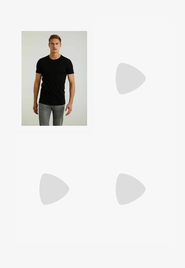 T-shirt nera a maniche corte in cotone, con colletto tondo e un piccolo logo inciso a forma di quadrato sul lato sinistro del petto. Indossata con jeans grigi chiari.; Jeans a gamba larga in denim grigio scuro con pannelli laterali grigio chiaro a contrasto. I dettagli con orlo grezzo esaltano il design unico. Stile a cinque tasche.; Scarpe da trekking in pelle nera con suola in gomma robusta, ganci metallici per i lacci e una design ad altezza caviglia per supporto e durata.; Occhiali da sole in plastica nera con lenti verdi, montatura quadrata, dettaglio argento sulla parte superiore e steli con texture. Marchio indicato sulla parte interna dello stelo.