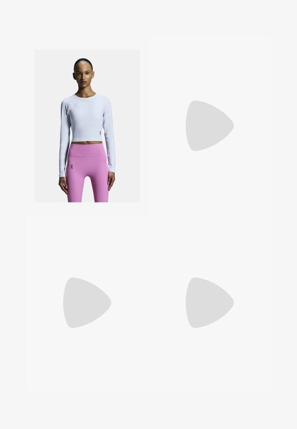 Biała, długorękawowa crop top z rękawami raglanowymi, połączona z różowymi legginsami o wysokim stanie z akcentem logo na lewej udzie.; Czarne sportowe spodenki z elastycznym pasem, wykonane z lekkiego materiału. Posiadają małe szare logo na dolnym prawym boku.; Białe buty sportowe z siateczkowymi i syntetycznymi wstawkami, z sznurowadłami, o zaokrąglonym kształcie, spoczywające na czarnej piłce do ćwiczeń, na ciemnym tle.; Okulary przeciwsłoneczne z białą oprawą, szarymi akcentami i niebieskimi lustrzanymi soczewkami. Sportowy design, kształt otaczający, z regulowanymi noskami.