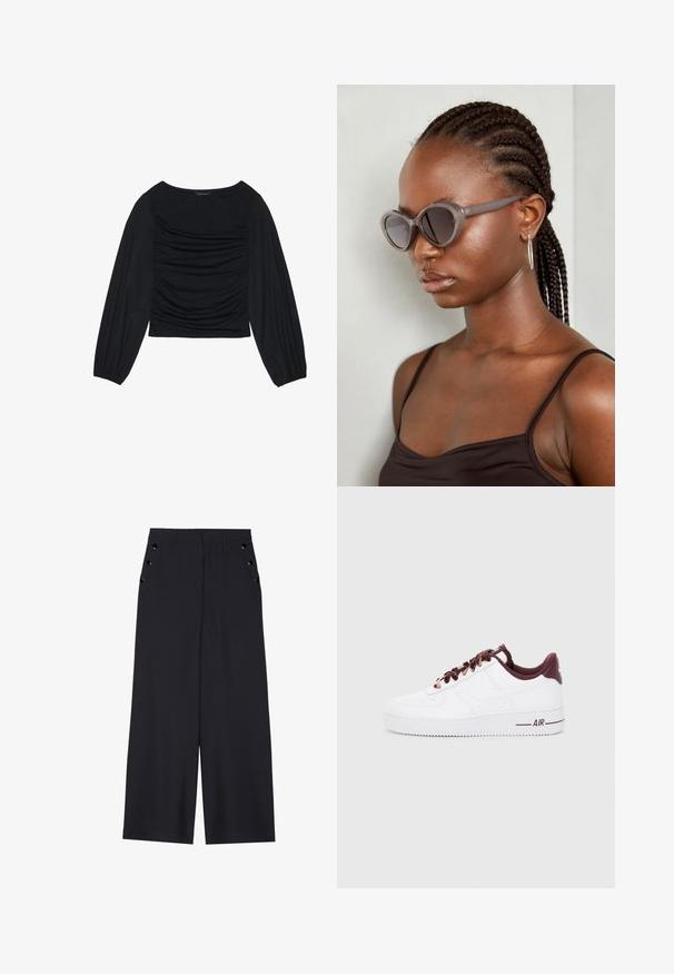 Top preto de manga longa com detalhe de tecido franzido na parte da frente e nos pulsos, feito de material suave e elástico com decote à barco.; Calças largas de tecido azul marinho escuro, com uma textura suave, pregas frontais e ilhoses decorativos em tom dourado nos bolsos laterais.; Sapatilhas de couro brancas com detalhes em vermelho escuro, apresentando atacadores redondos, um colarinho acolchoado e solas de borracha texturizada. "AIR" impresso na lateral.; Óculos de sol cinzentos de tamanho oversized com uma forma arredondada e lentes escuras. Armação de plástico elegante com um acabamento suave. O modelo tem cabelo trançado.