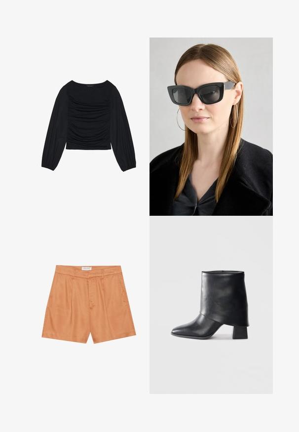 Top noir à manches longues présentant un détail de tissu froncé à l'avant et aux poignets, fabriqué en matière douce et extensible avec un col bateau.; Shorts plissés orange en tissu lisse, avec une fermeture éclair à l'avant, des passants de ceinture et des poches latérales. L'étiquette indique "ANNA FIELD."; Bottine en cuir noir à bout pointu, texture lisse et talon bloc structuré. Elle se distingue par un design de revers haut et plié.; Des lunettes de soleil en forme de chat noir avec des verres foncés, des montures épaisses et des accents subtils. Portées avec un manteau noir et un haut gris, avec des cheveux longs et raides.