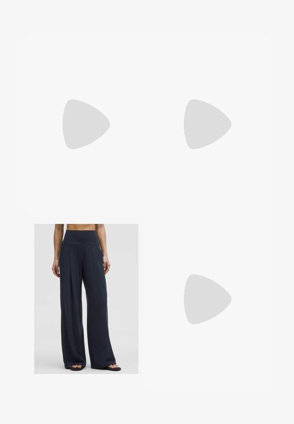 Burgundin värinen neulottu crop-top, jossa on V-pääntie, valkoiset ja vaaleansiniset raidat kauluksessa, lyhyet hihat ja valkoinen brodeerattu "01" -koristus.; Nainen seisoo päällään korkeat vyötäröhousut, joissa on leveät lahkeet, yhdistettynä sandaaleihin, esittäen mukautuvaa ja rentoa tyyliä.; Ruske ante suede slip-on čevlji z teksturiranim, svetlejšim ovratnikom. Gumijast podplat z vzorčastimi oprijemi, nosi se z belimi rebrastimi nogavicami.; Ruske oválne slnečné okuliare s tmavými sklami. Rám je vyrobený z priesvitného hnedého materiálu a na stranách má potlačené logo.; Kankaan vaalea olkalaukku, jossa on rento muotoilu ja yksi olkahihna. Pintarakenteessa on teksturoitu kuvio.