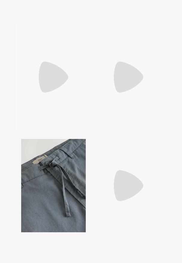 Long-sleeve shirt in a camo pattern featuring shades of brown, green, and gray, with a round neck and a relaxed fit. Textured surface resembles tree bark.; Gray fabric shorts with a soft texture, featuring a knotted drawstring and belt loops. Label indicates "NEXT" brand at the waistband.; Black sandal featuring braided straps, a flat sole, and a buckled ankle strap. Made from synthetic material with a smooth finish.; Black sunglases with octagonal frame, dark lenses, glossy finish, thin temples, and gold accents on the front.