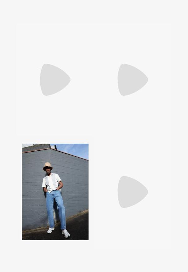 T-shirt cinza feito de tecido misto de algodão, com decote redondo, mangas curtas e um pequeno emblema da CK no lado esquerdo do peito.; Camisa branca de manga curta com riscas cinza claro, jeans de ganga azuis e sapatilhas brancas, posicionada contra uma parede cinza sob um céu azul limpo.; Botim Chelsea em couro preto com painéis laterais elásticos e uma alça, apresentando um bico arredondado e sola de borracha texturizada.; Conjunto de seis anéis metálicos prateados em várias formas, incluindo redondos e quadrados, apresentando texturas suaves e um design minimalista.