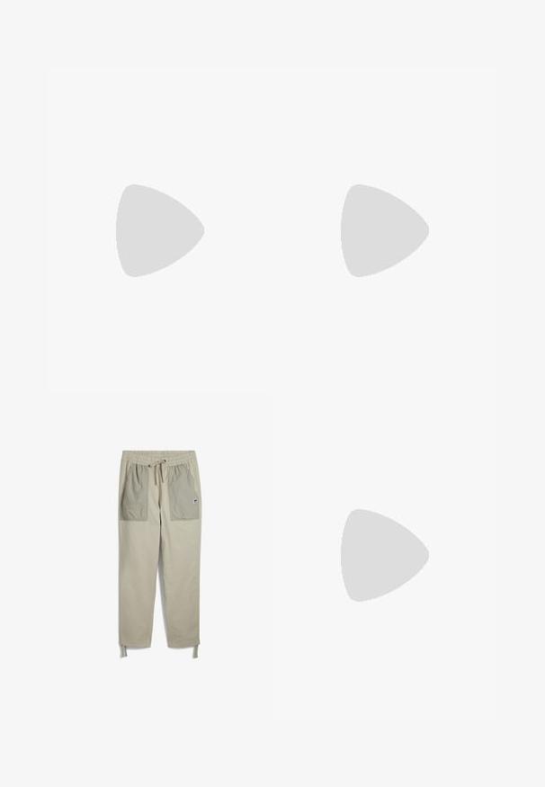 T-shirt en coton beige avec une illustration graphique de bottes, accompagné du texte "Bottes Timberland avec des Racines" en dessous. Manches courtes, coupe décontractée.; Pantalons beige avec une taille élastique, cordon de serrage, deux grandes poches avant d'une teinte plus claire et des sangles ajustables aux chevilles.; Baskets en suede noir avec semelles en caoutchouc blanc, présentant un design à lacets, des accents texturés et une branding discrète, associées à un pantalon marron.; Sac en bandoulière en tissu marron avec fermeture éclair et poche avant ; porté sur une chemise à manches longues rayée grise et orange avec un patch logo.