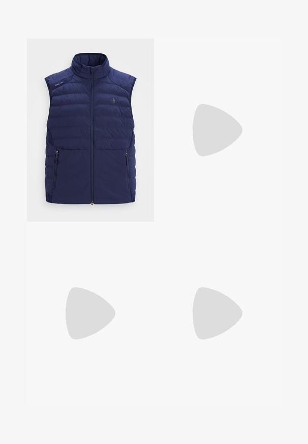 Mörkblå quiltad ärmlös väst med ståkrage, framsida med dragkedja, sidofickor med dragkedja och broderad logotyp på bröstet.; Vit polo t-shirt, kortärmad, klassisk krage, tre-knapplist, röd logotype på kragen och ärmen, slät tyg, normal passform.; Under Armour MATCHPLAY TAPERED - Tygbyxor - steel; Vita sportskor med en slät syntetisk ovandel, blå akcentuerade delar, strukturerad marinblå häl och en lätt, spetsad sula för bra grepp.