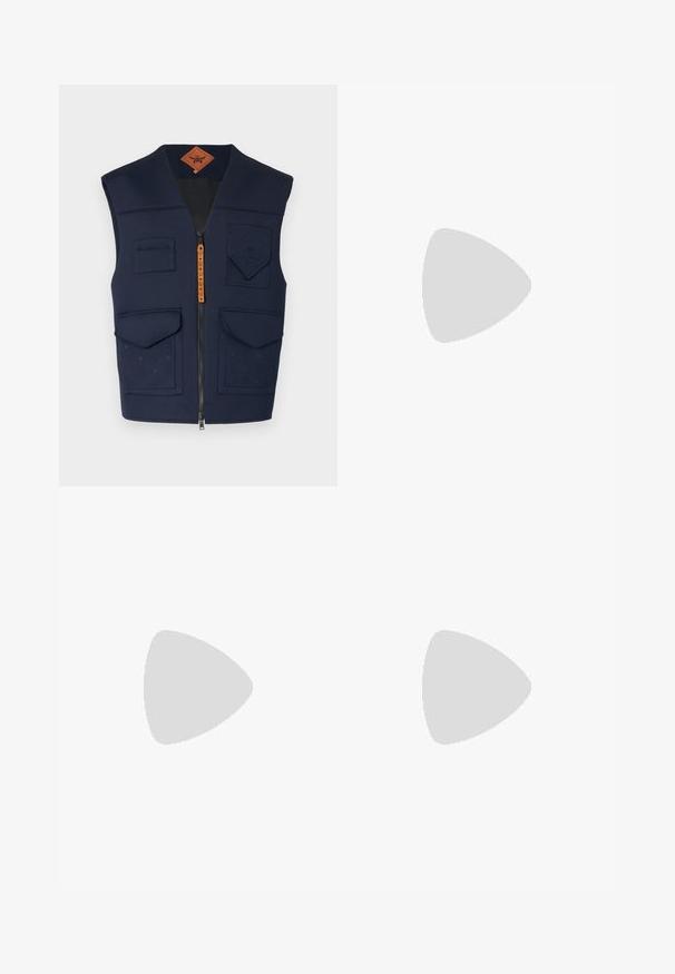 Gilet marine avec fermeture éclair à l'avant, plusieurs poches et un motif en relief. Il présente une texture matelassée et une étiquette en cuir marron.; T-shirt en coton blanc avec un col rond et des manches courtes, orné d'un logo doré EA7 Emporio Armani imprimé sur le devant.; Shorts de sport noirs en tissu doux, avec une taille élastique et un petit logo jaune EA7 sur le bas de la jambe gauche.; Baskets en cuir blanc avec une finition lisse, bout arrondi, lacets plats et semelle texturée. Présente un logo discret sur le talon.