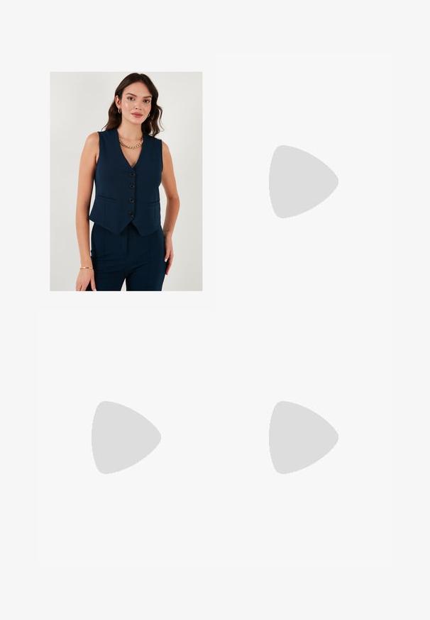 LELA SLIM FIT - Smanicato - dark blue; Top a maniche lunghe bianco con collo rotondo. Realizzato in un tessuto elasticizzato che si adatta al corpo. Presenta delle sottili righe orizzontali.; Jeans in denim blu chiaro con una vestibilità rilassata, gamba dritta, design a cinque tasche e una leggera scoloritura su tutto il tessuto.; Scarpe sportive con tomaia in pelle bianca, punta in suede grigia e tre strisce nere. Presentano un logo blu sulla linguetta e una suola in gomma testurizzata.